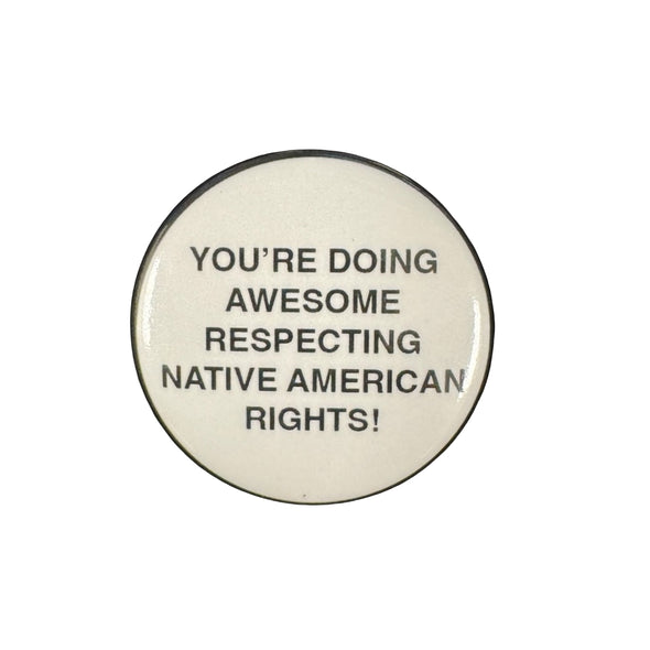 Button badge with text 'YOU'RE DOING AWESOME RESPECTING NATIVE AMERICAN RIGHTS!' on a black background