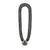 Black beaded necklace with a circular pendant on a white background